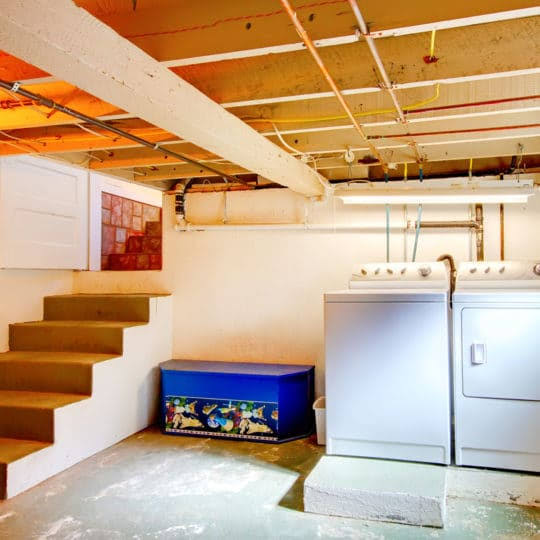 Professional crew removing furniture and heavy items during a basement cleanout service in Charlottesville VA