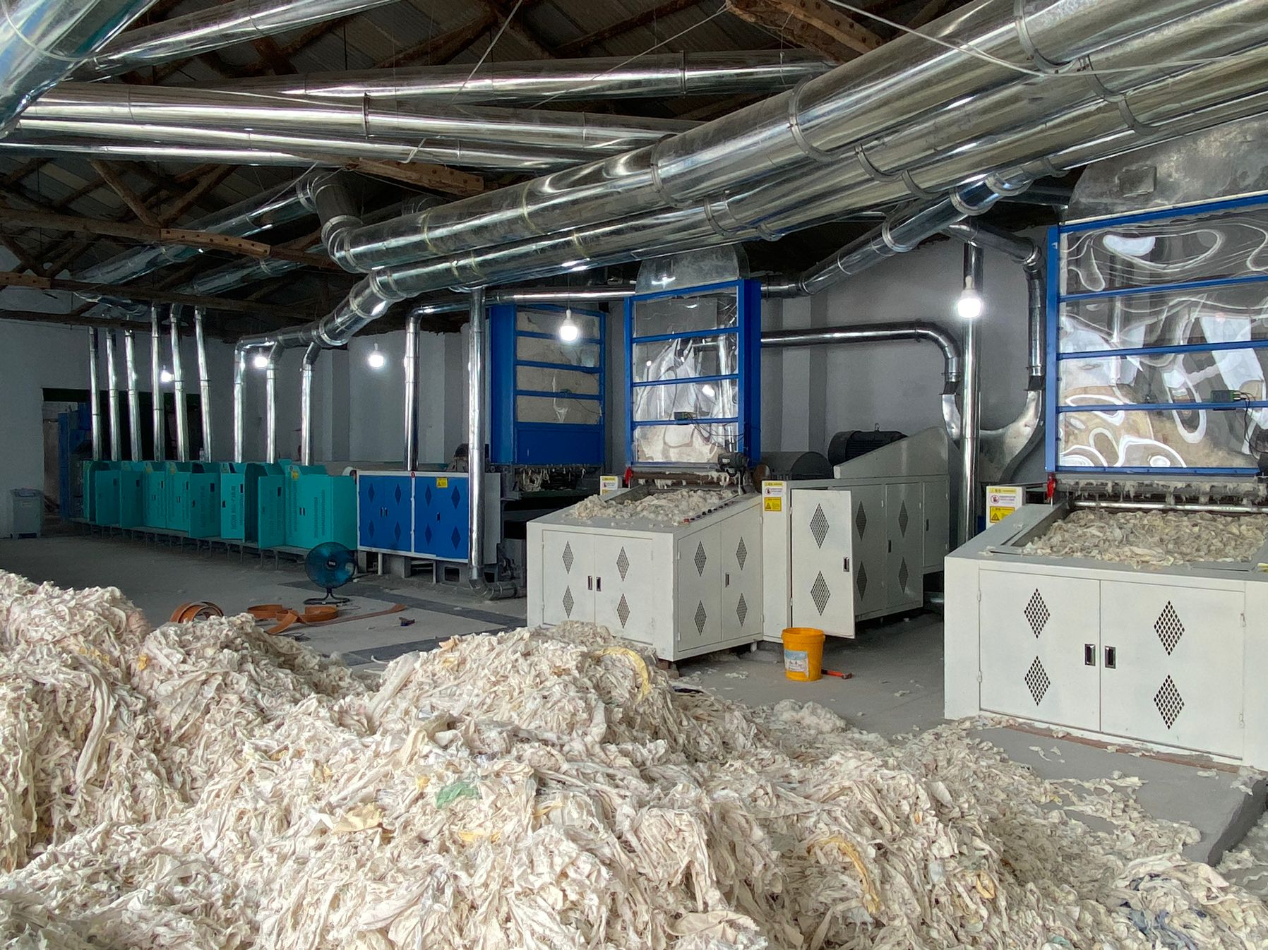 Large textile processing facility with industrial equipment and material waste