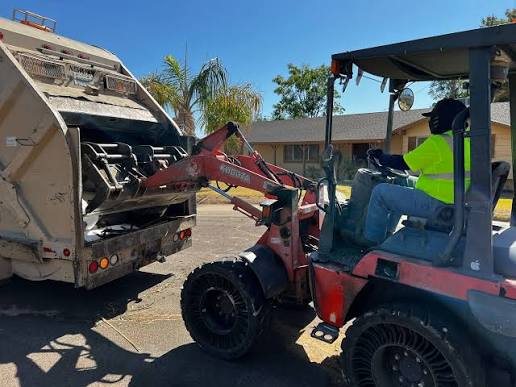 Professional junk removal crew clearing a heavy appliance from a narrow, steep residential basement in Charlottesville VA