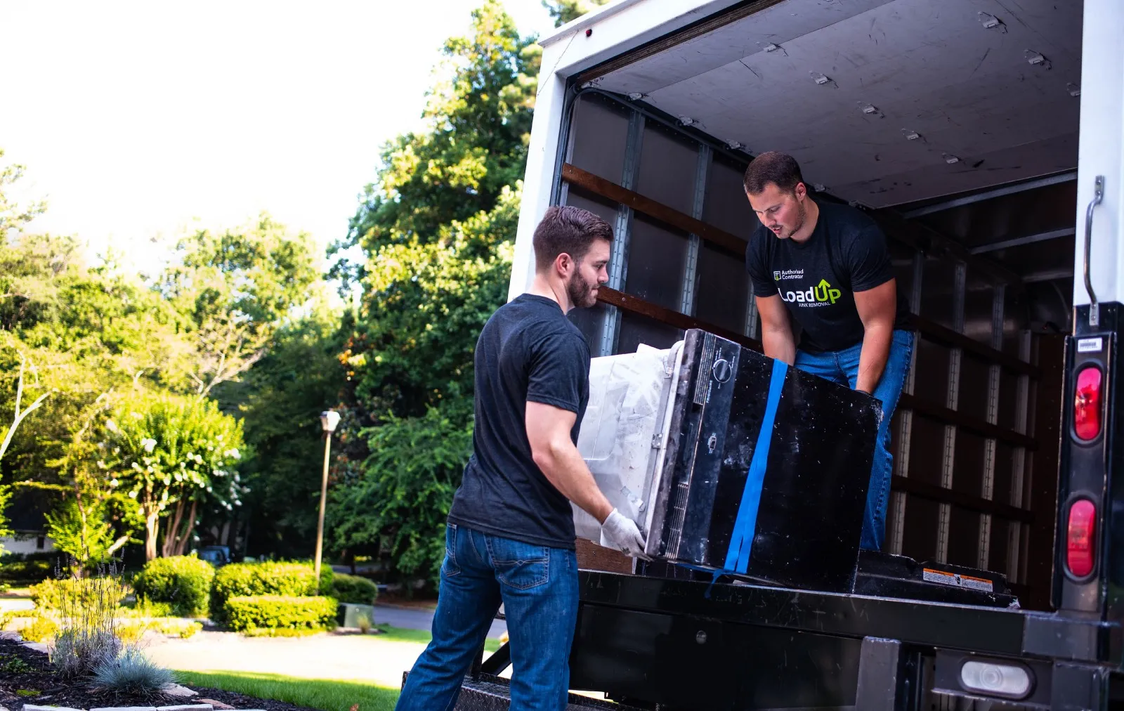 Junk removal professionals loading household furniture into a truck during a residential cleanout in Crozet, Virginia.