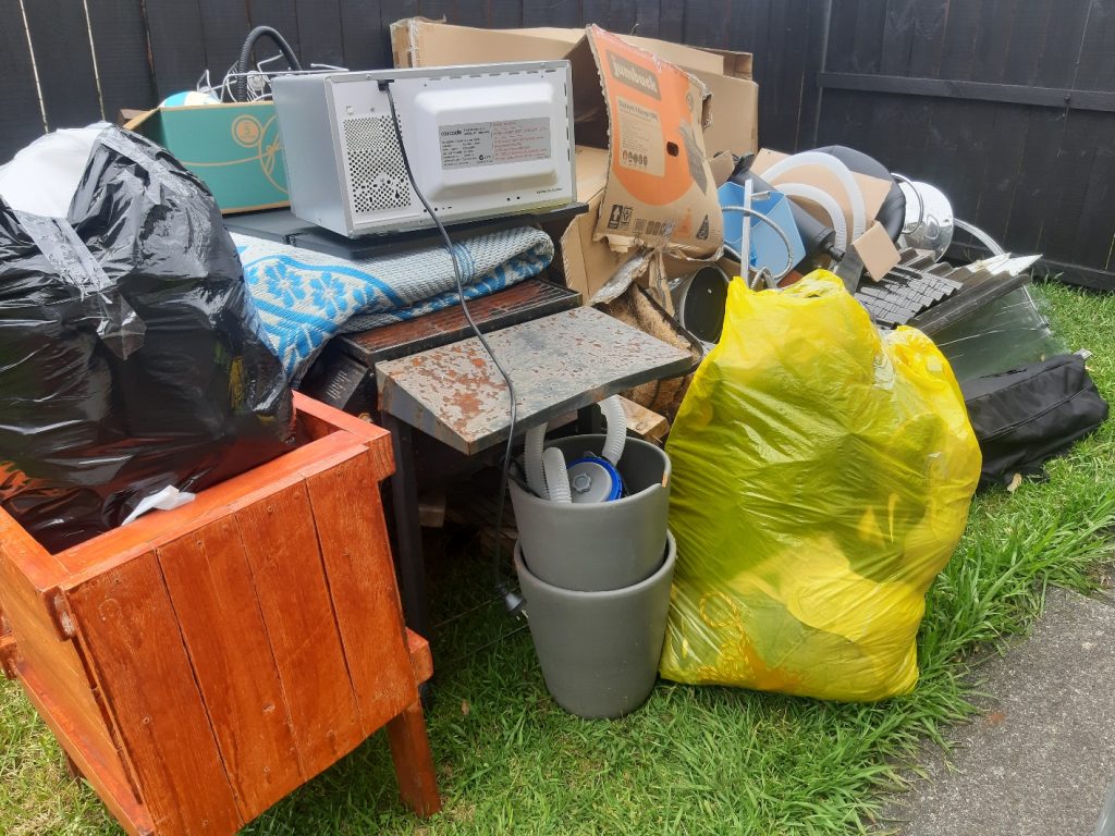 Household furniture, electronics, boxes, and bagged waste prepared for an estate cleanout in Fry's Spring, Charlottesville.